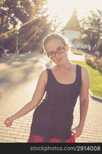 young 20s blond haired women posing outdoors weared black tank top in glasses. Shi is very pretty and fresh looking. Cute young lady outdoors rejoice of warm weather fall