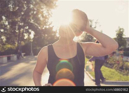 young 20s blond haired women posing outdoors weared black tank top in glasses. Shi is very pretty and fresh looking.