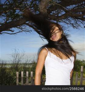 Young adult Asian female screaming and swinging her hair.