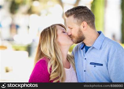 Young Adult Caucasian Couple Kissing Portrait At The Park.
