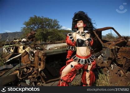 Young adult Caucasian female dressed in pirate costume in junkyard.