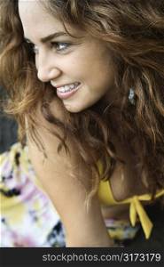 Young adult Caucasian female smiling with hair blowing.