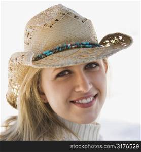 Young adult Caucasian female wearing cowboy hat smiling at viewer.