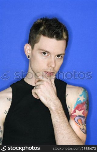 Young adult Caucasian male pierced ear and tattoo.