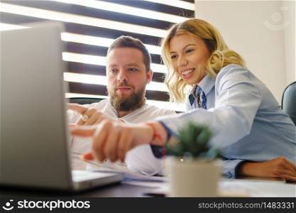 Young adult caucasian man and woman working on the laptop computer
