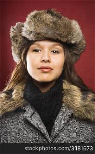 Young adult Caucasian woman wearing fur hat looking at viewer.