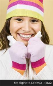 Young adult Caucasian woman wearing winter hat and gloves and smiling at viewer.
