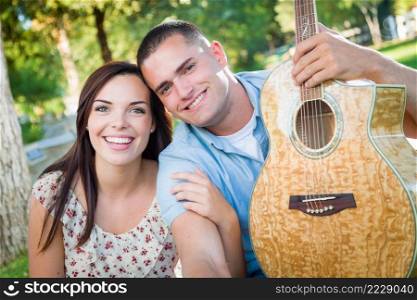 Young Adult Couple Portrait with Guitar in the Park.