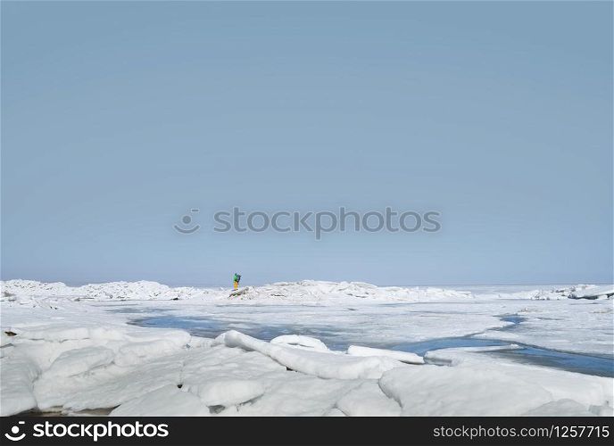 Young adult man with backpack outdoors exploring icy landscape