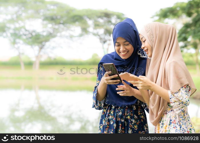 Young adult teenager Muslim Islamic Thai Asian women using smartphones and tablet in social media.