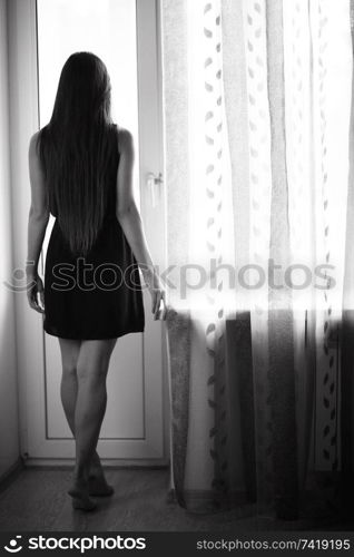 young adult woman at the window