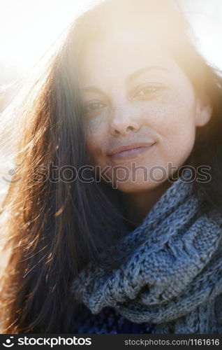 Young adult woman outdoors smiling and looking at camera