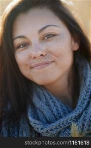 Young adult woman outdoors smiling and looking at camera