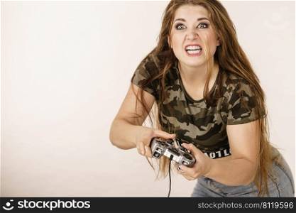 Young adult woman playing on the video console holding pad being very into game. Gaming gamers concept.. Gamer woman holding gaming pad