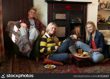 Young adults making toast on open fire