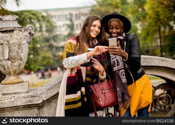 Young african american and caucasian women taking selfie outdoor