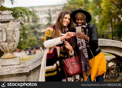 Young african american and caucasian women taking selfie outdoor