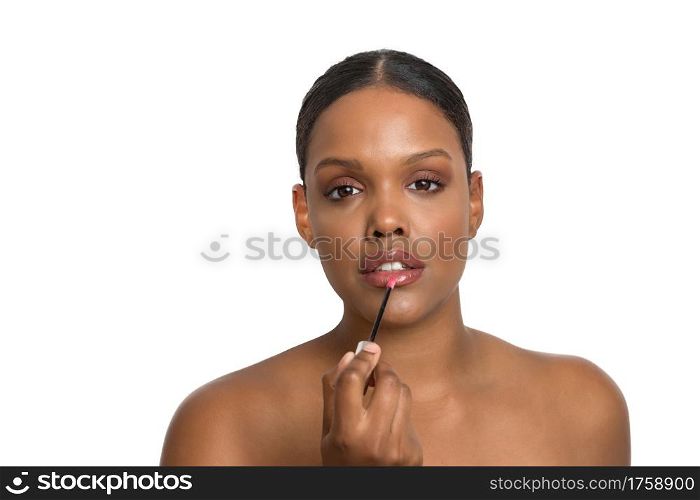 Young African-American beauty model with flawless and smooth skin seriously applying lipstick on a white background.