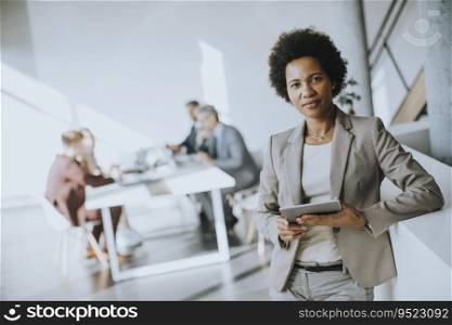 Young African American businesswoman standing using digital tablet in the modern office