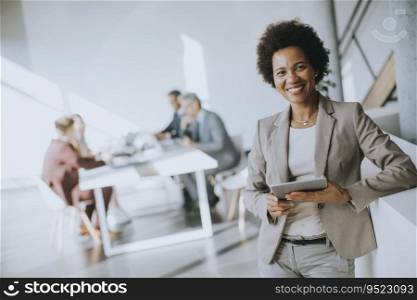 Young African American businesswoman standing using digital tablet in the modern office