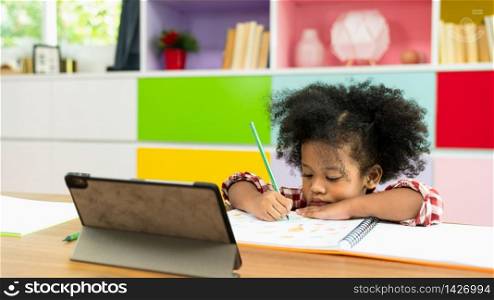 Young African American kid girl studying using digital tablet, preschool child study at home school. Children education, self isolation, coronavirus outbreak social distancing or homeschooling concept