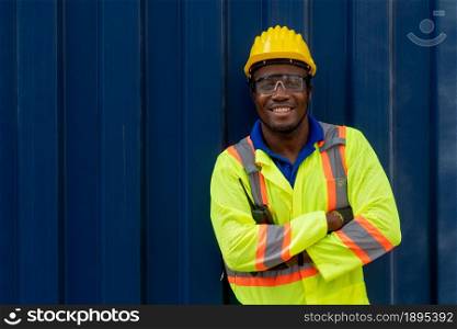 Young African American male worker at overseas shipping container yard . Logistics supply chain management and international goods export concept .. Young African American male worker at overseas shipping container yard