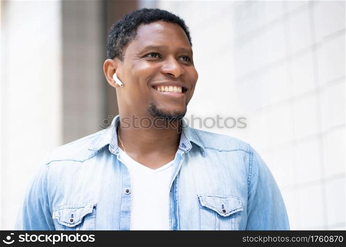 Young african american man walking outdoors on the street. Urban concept.