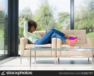 Young african american woman at home relaxing in her luxury lliving room reading a digital tablet surf internet and work