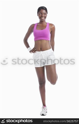 Young African American woman exercising over white background