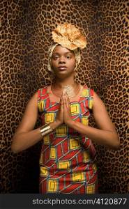 Young African American Woman Praying and Wearing Traditional African Dress