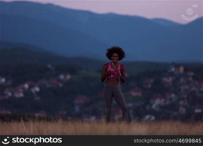 young African american woman runner with headphones jogging outdoors in nature beautiful summer night - Fitness, people and healthy lifestyle