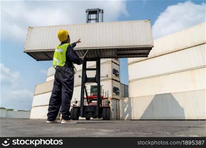 Young African American woman worker at overseas shipping container yard . Logistics supply chain management and international goods export concept .. Young African American woman worker at overseas shipping container yard