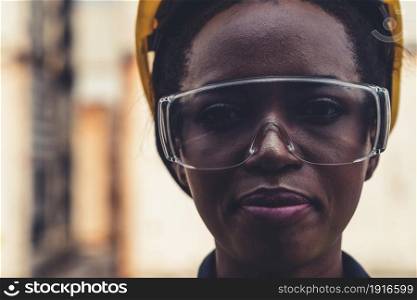 Young African American woman worker at overseas shipping container yard . Logistics supply chain management and international goods export concept .. Young African American woman worker at overseas shipping container yard