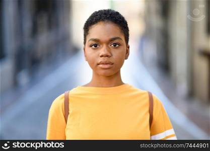 Young African woman wearing casual clothes looking at camera. Girl with very short hair.. Young African woman wearing casual clothes looking at camera.