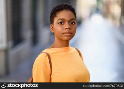 Young African woman wearing casual clothes looking at camera. Girl with very short hair.. Young African woman wearing casual clothes looking at camera.