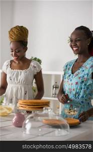 Young african women at the kitchen cooking cake with strawberry