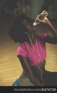 young afro american woman in gym on pilates workout break teaking breath and fresh drinking water. young afro american woman in gym have pilates workout break