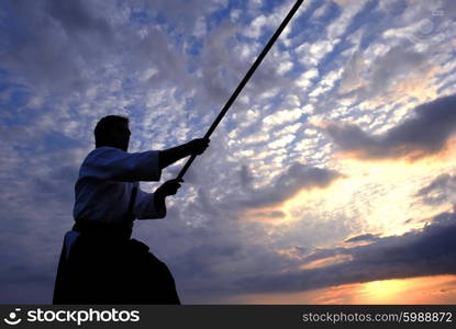 young aikido man fighter at sunset light