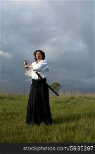 young aikido man with a sword outdoors