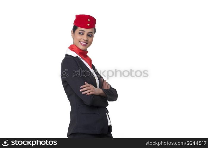 Young air hostess with arms crossed looking away against white background