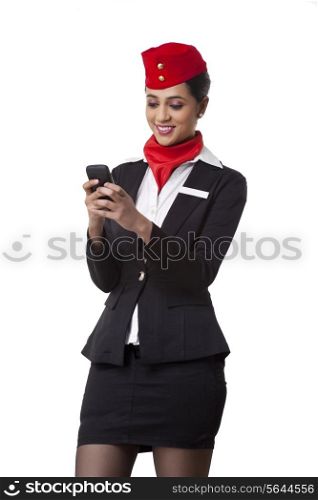 Young airhostess text messaging on cell phone isolated over white background