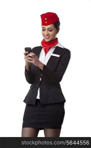Young airhostess text messaging on cell phone isolated over white background