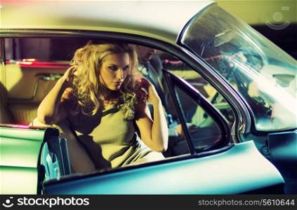 Young alluring couple in the shiny retro car