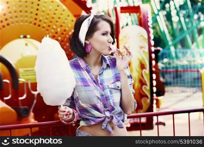 Young American Woman in Amusement Park Eating Cotton Candy
