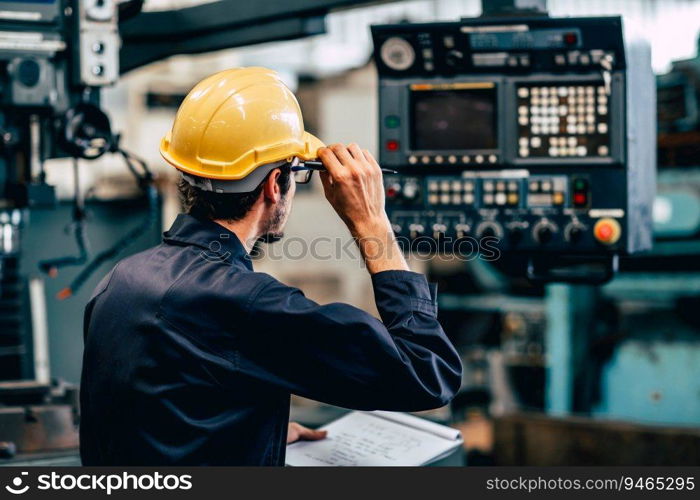 Young American worker intend to work in a heavy industrial factory looking and control machine in production line.