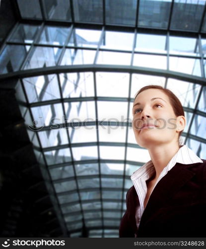 Young and ambitious businesswoman looks at the future in front of an office building.