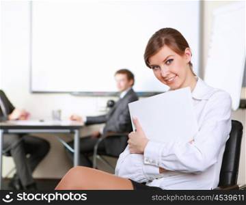young and attractive businesswoman in an office with collegues on the background