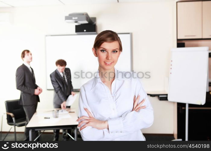 young and attractive businesswoman in an office with collegues on the background