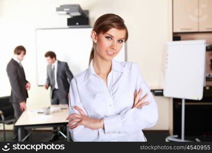 young and attractive businesswoman in an office with collegues on the background