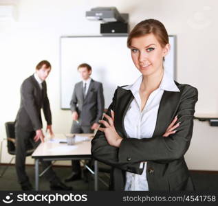 young and attractive businesswoman in an office with collegues on the background